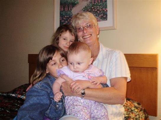 A grandmother enjoys a heartwarming moment with her grandchildren, sharing love and laughter.