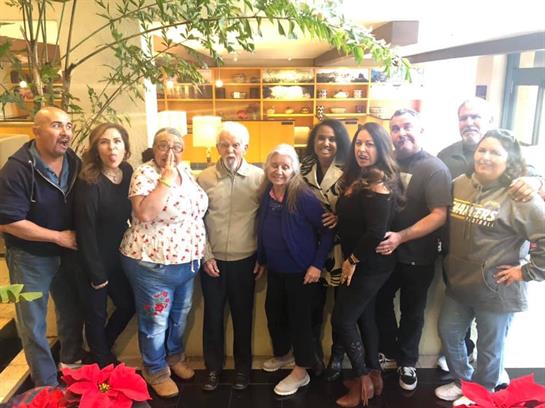 A joyful group of family and friends gathers together, immersed in conversation and laughter.