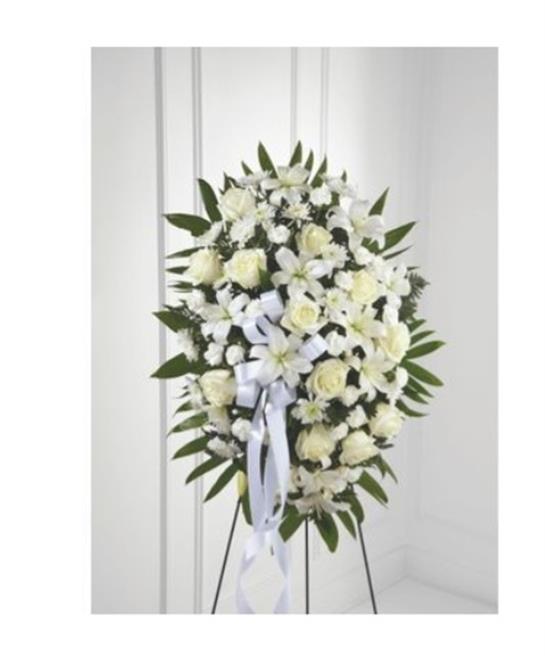 A beautiful display of white roses and greenery arranged elegantly for a memorial setting.