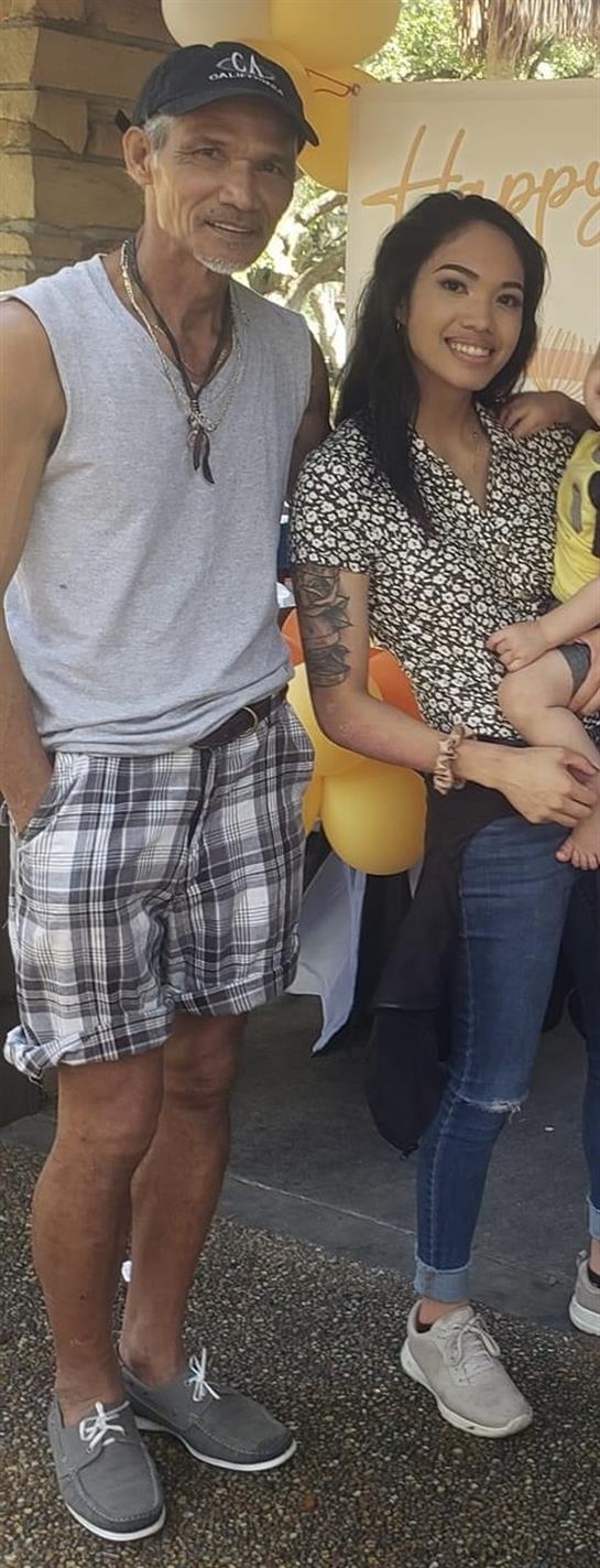 Family members gather in a park, holding balloons and enjoying a sunny day with kids.