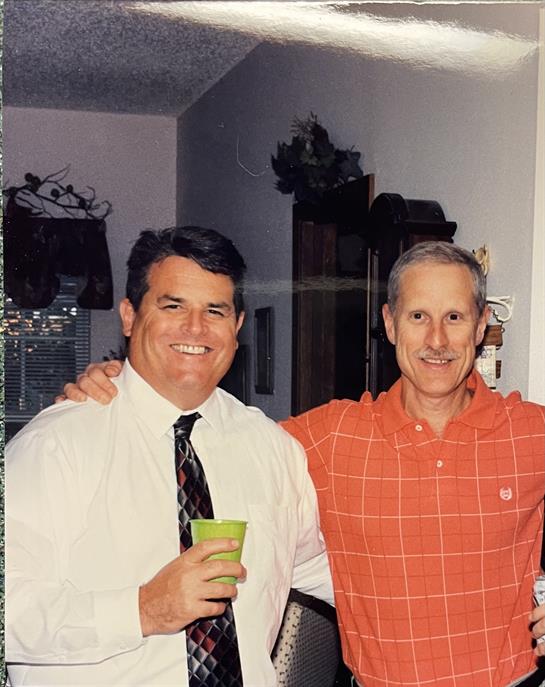 Two friends enjoy their time together, smiling and celebrating in a warm indoor setting.