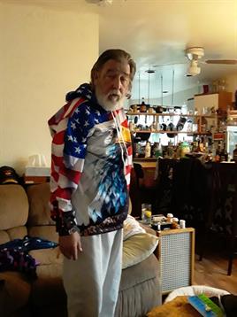 A man standing in a room with a flag on his jacket