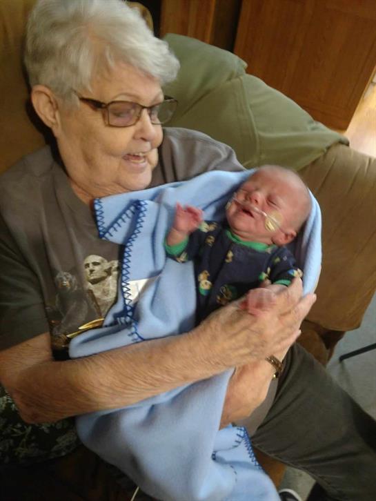 An elderly woman holding a baby