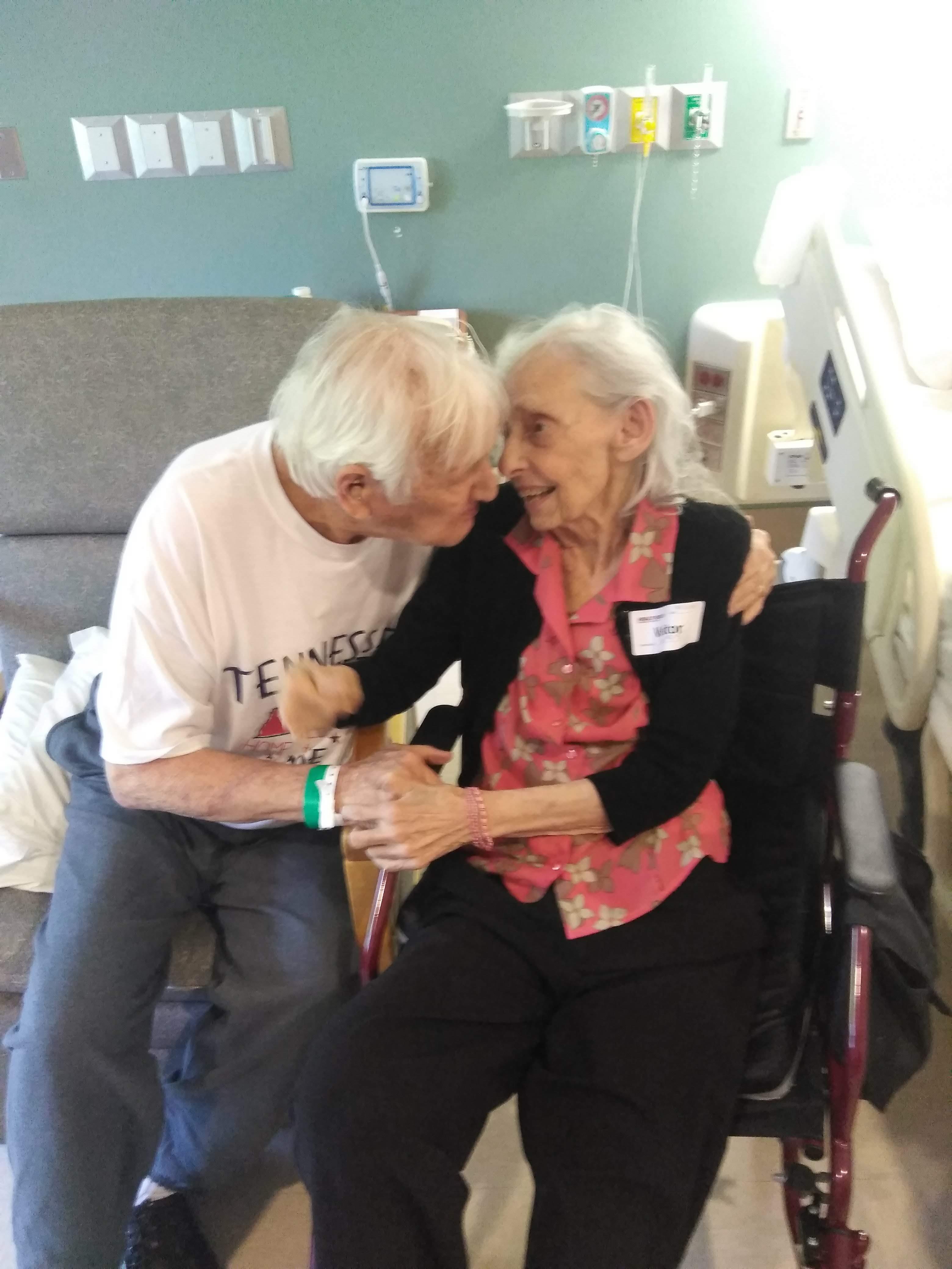 A devoted couple enjoys a heartfelt connection while seated in a hospital room.