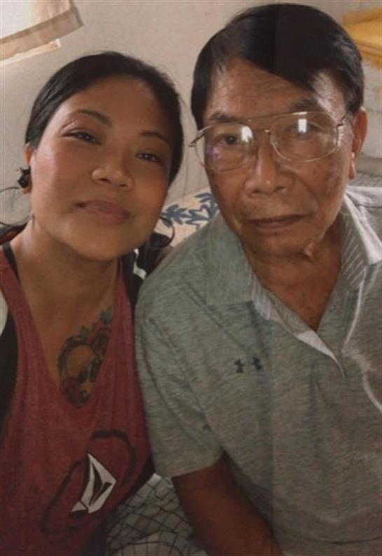 Two adults smile warmly at the camera, embracing a moment together in a relaxed atmosphere.