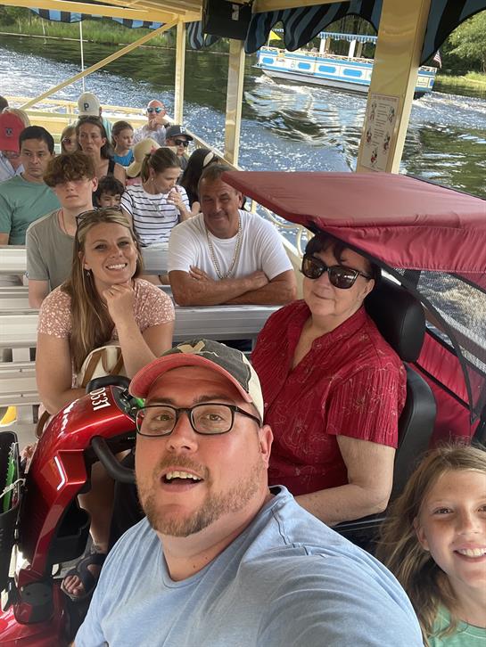 A diverse group is gathered on a boat, sharing moments of joy and friendship under the sun.