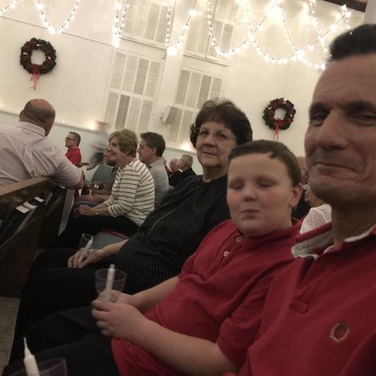 Group of people enjoying a festive celebration in a warmly lit space decorated for the holidays.