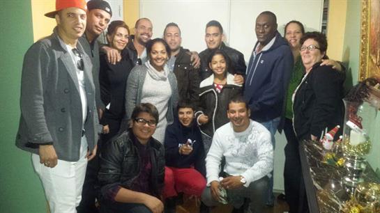A lively group of friends enjoys a fun gathering indoors, smiling and posing together with joy.