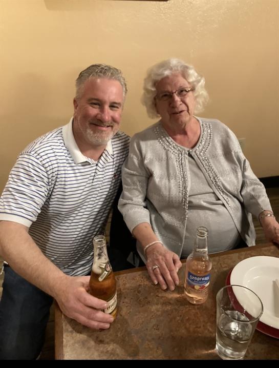 A man and woman sitting at a table with bottles of beer