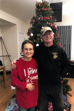 A man and woman standing in front of a christmas tree