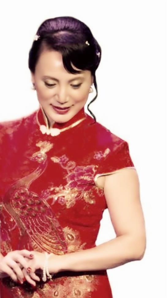 A woman in a red traditional dress performs with elegance during a cultural event.