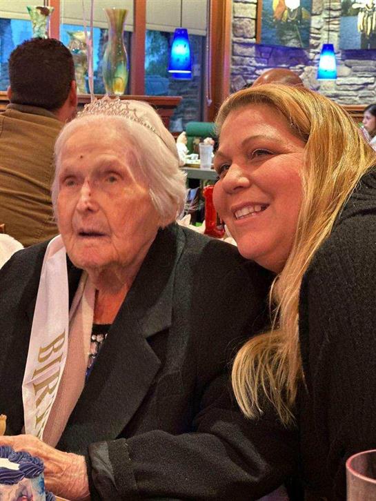 A joyful grandmother celebrates a special occasion with a family member at a gathering.