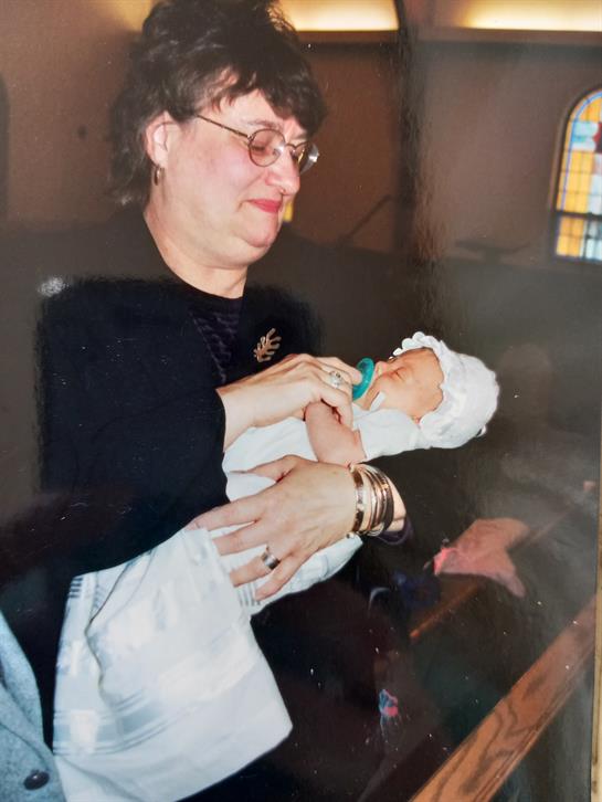 A woman cradles a newborn baby, sharing a tender moment in a cozy, familial environment.