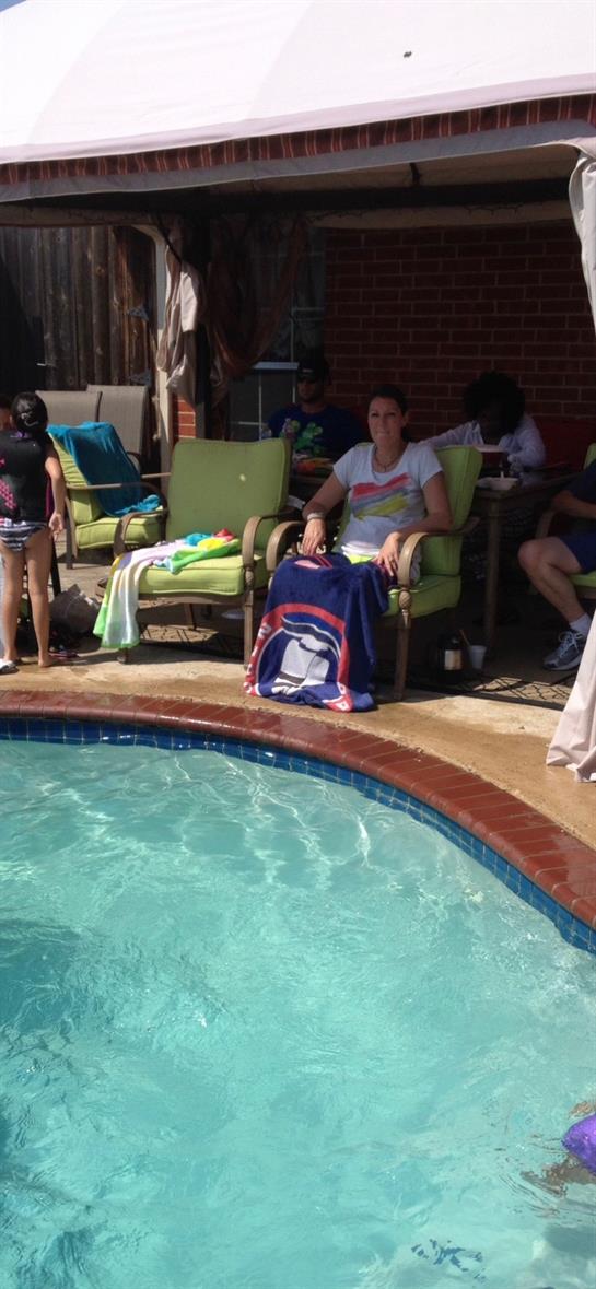 A woman sitting in a chair next to a pool