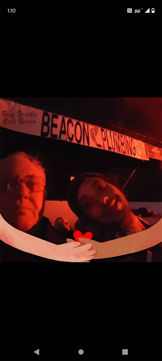 Two friends share a joyful moment together, enjoying their time at a lively event in the evening.