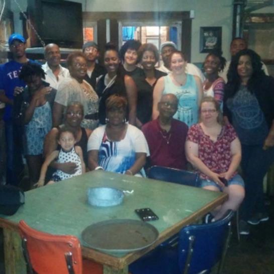Family and friends share laughter and stories at a warm, inviting restaurant table.