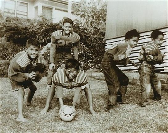 Group of kids joyfully playing soccer, displaying teamwork and enthusiasm in a lively atmosphere.
