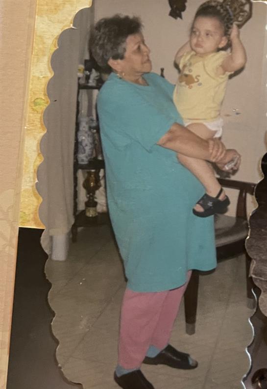 A loving grandmother embraces her cheerful toddler in a cozy living room filled with warmth.