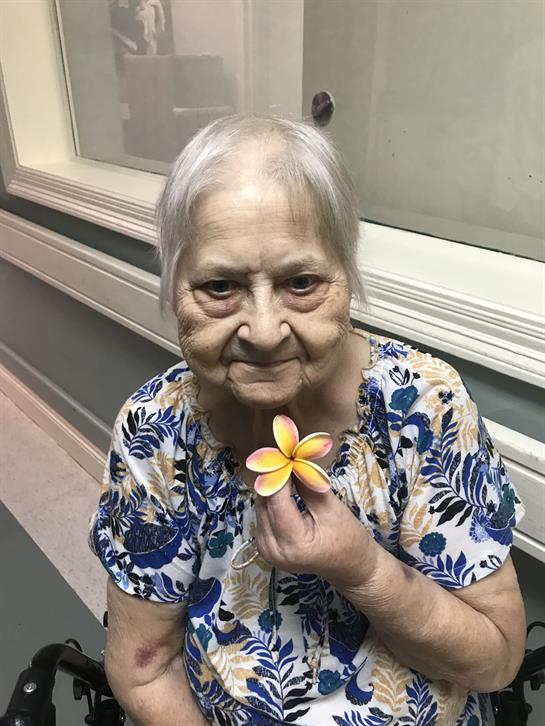 An old woman holding a flower