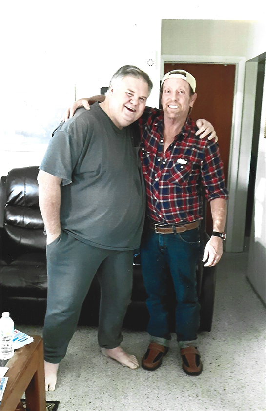 Two friends embrace happily in a relaxing living room, enjoying each other's company.