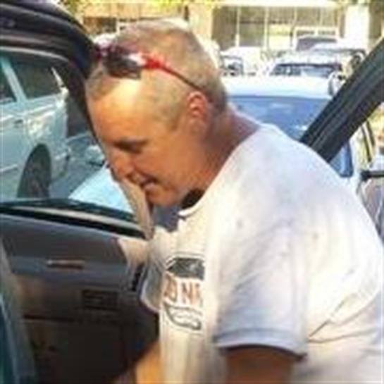 A man looking into the door of a car