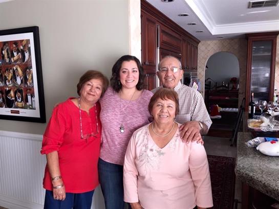 Four family members joyfully pose together in a warm and inviting home atmosphere.