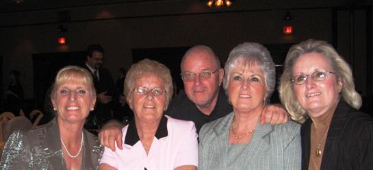 Three relatives pose together, enjoying quality time during a festive gathering in the evening.