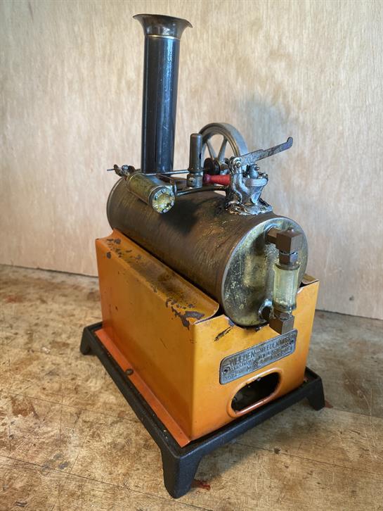 A vintage steam engine proudly displays intricate engineering in a workshop.