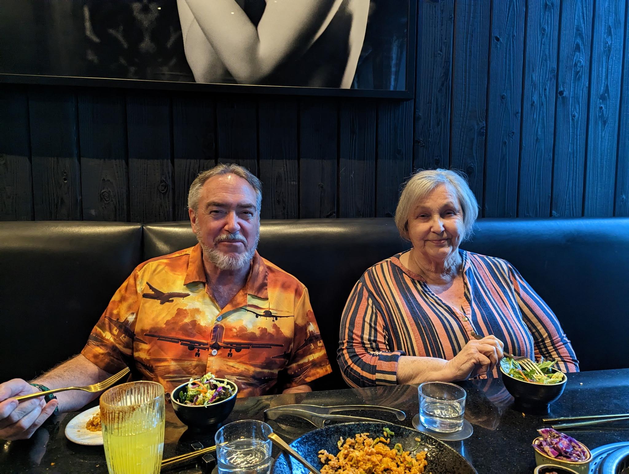 Couple shares a joyful dinner at a modern eatery, smiling and savoring their flavorful meals.