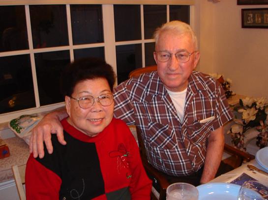 Two friends share a joyful moment at a dinner gathering, highlighting connection and comfort.