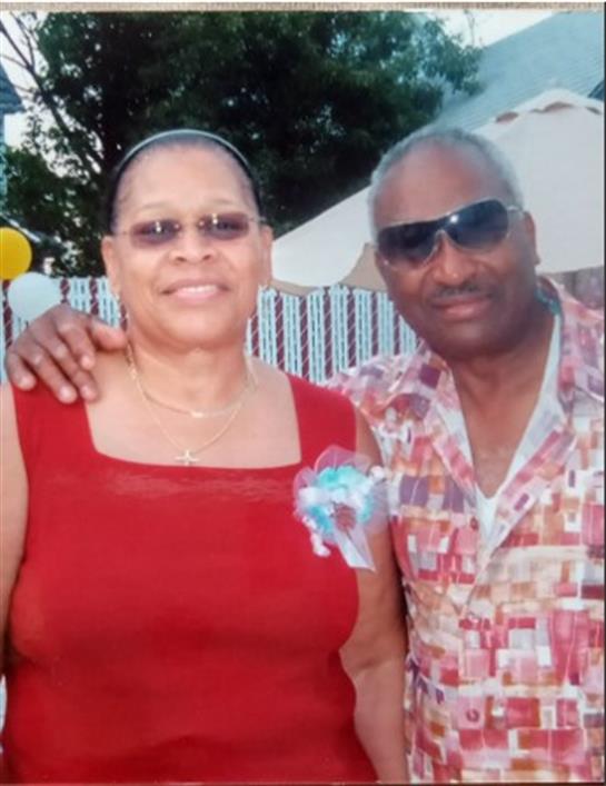 A joyful couple enjoys their time at an outdoor event, smiling and posing for the camera.