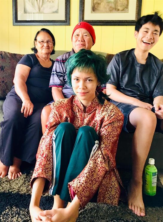 Four family members enjoy a relaxed moment together, laughing and connecting in their living room.