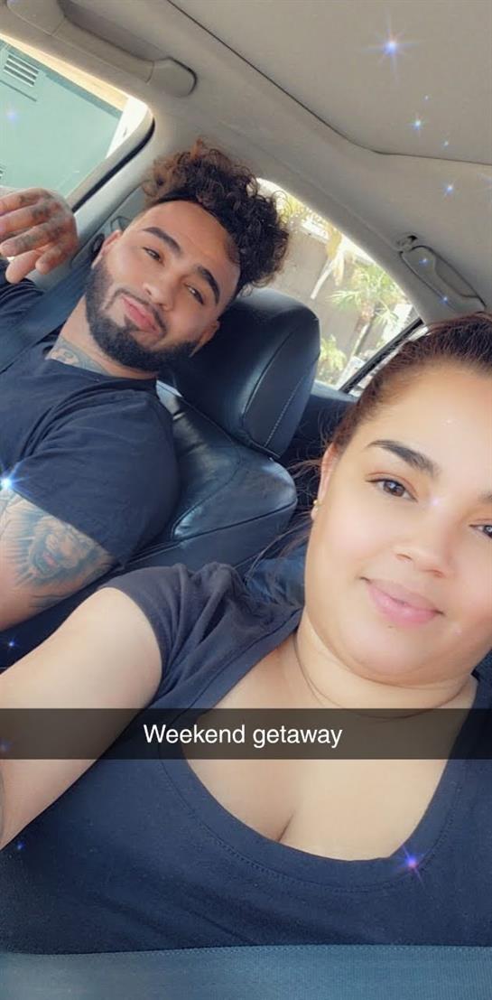 A happy couple poses in a car, ready for a weekend getaway, smiling in the warm sunlight.