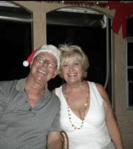 Cheerful couple poses together, enjoying a festive evening in a cozy setting.