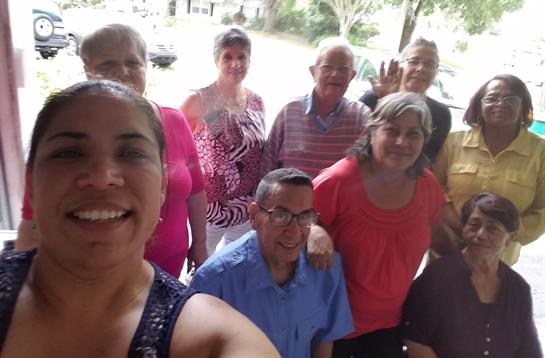 Friends gather together, smiling and enjoying each other's company on a sunny day.