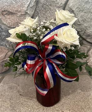 A vase with flowers and a ribbon