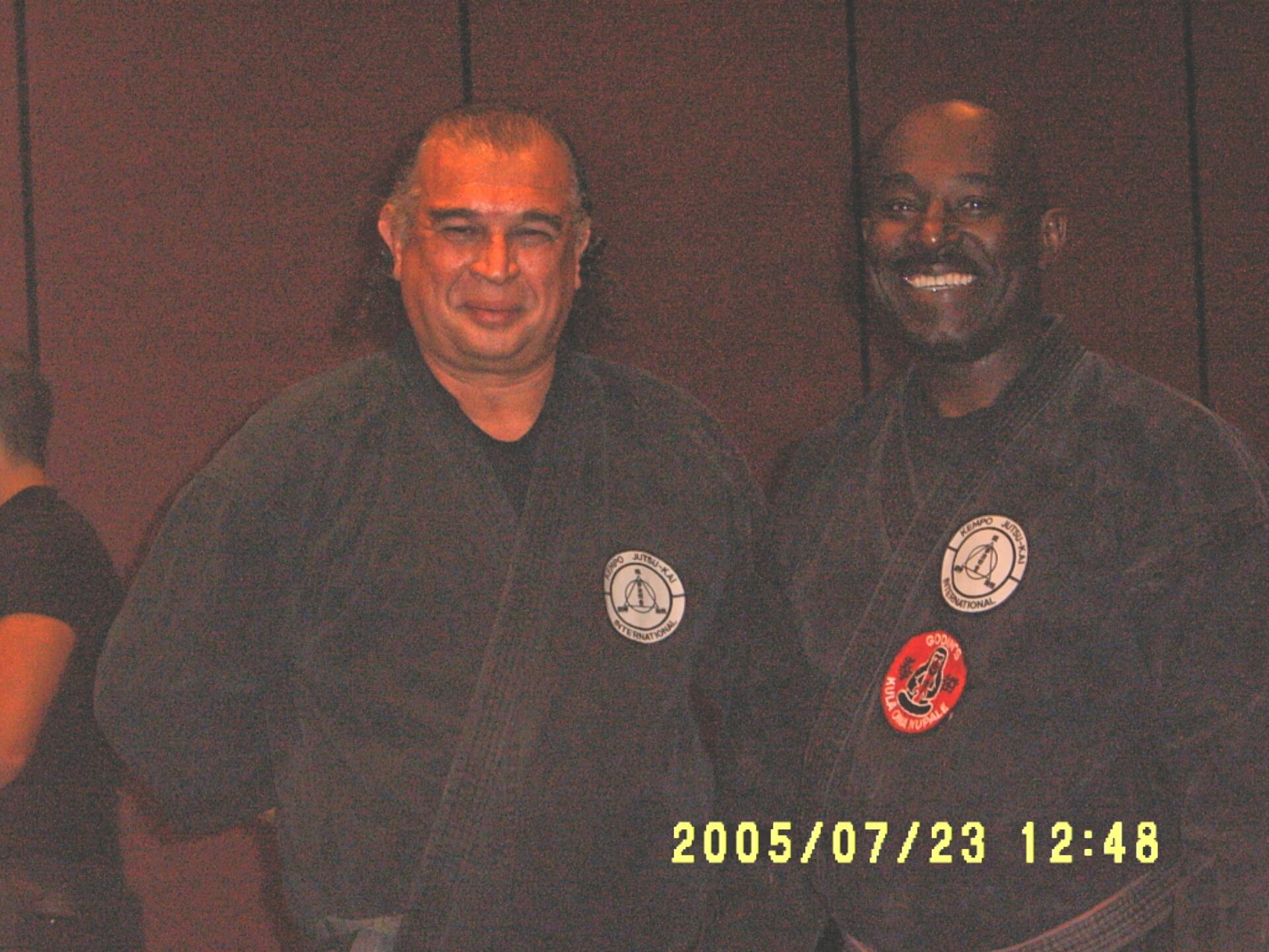 Two martial arts instructors pose together, displaying unity and dedication during a training event.
