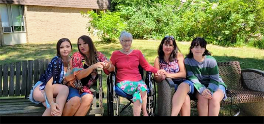 A group of women sitting in wheelchairs outside