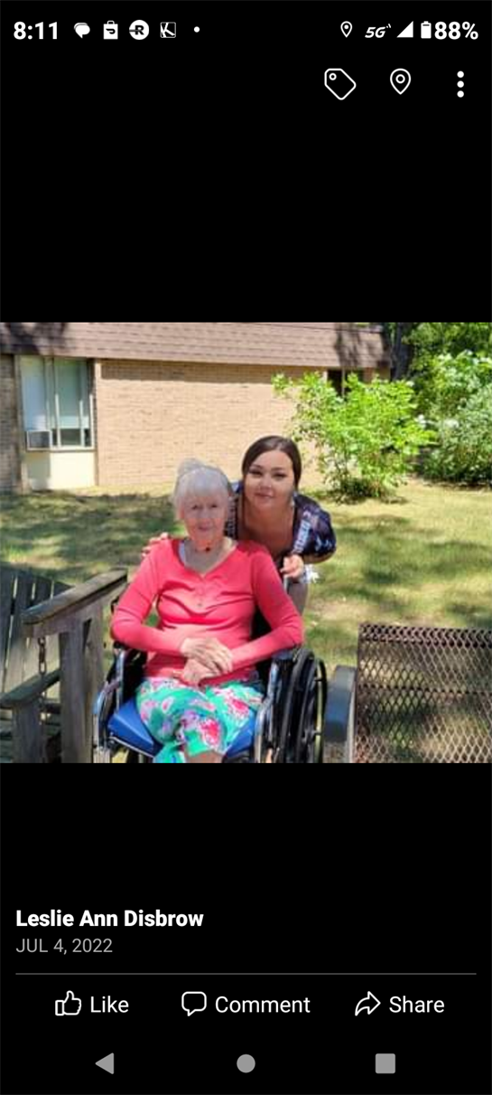 A woman in a wheelchair with an elderly woman in a yard
