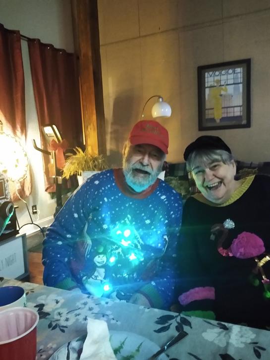 A man and woman sitting at a table with lights