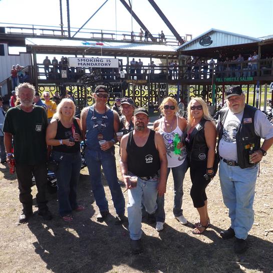 A cheerful group enjoys a gathering at a lively outdoor festival under clear skies.