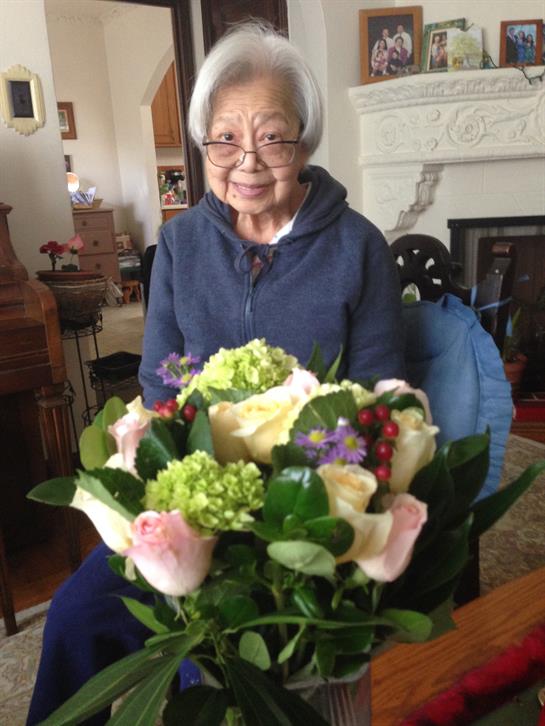 A woman enjoys a colorful bouquet of flowers in her warm and inviting living room.