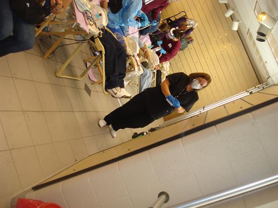 Caregivers support patients in a busy community clinic with various activities ongoing.