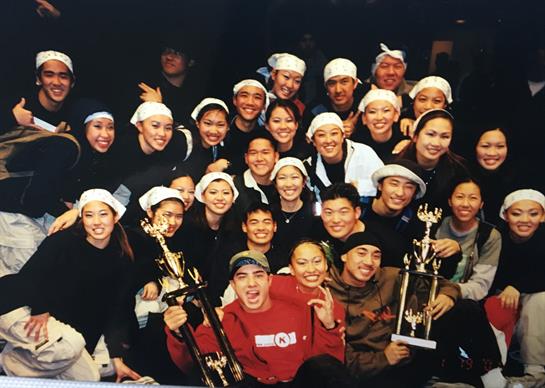 Dancers smile and pose with their trophies, celebrating their success together.