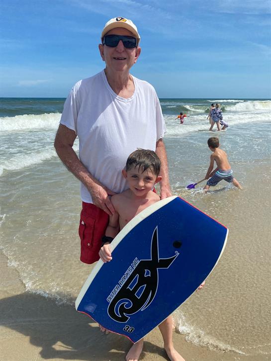 A man holding a boy on a beach