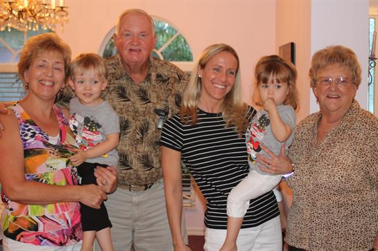 A joyful family poses together, showcasing love and connection on a warm evening.