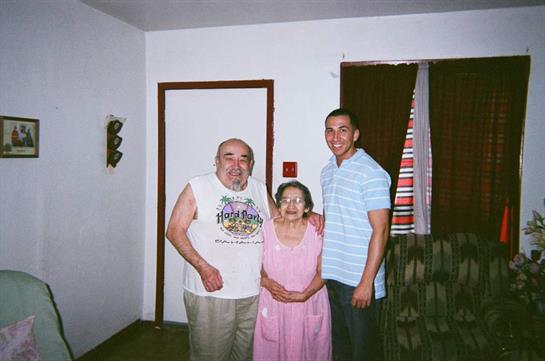 Three family members pose joyfully in a warm living room, showcasing their love and togetherness.