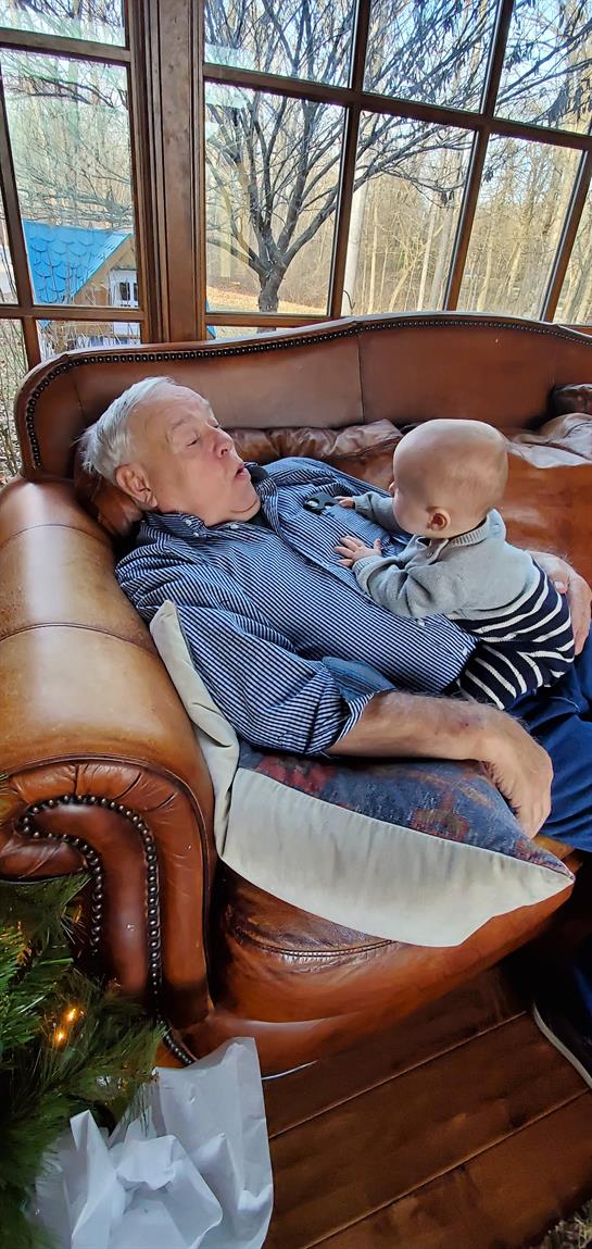 A man lying on a couch with a baby