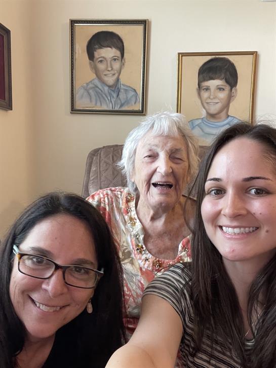 Three generations gather together, smiling and enjoying quality time in a warm living space.