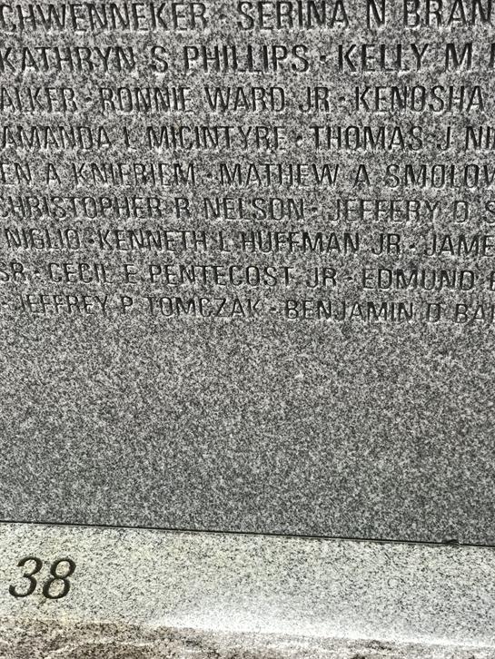 Names of honored individuals are beautifully engraved on a stone memorial, reflecting their legacy.